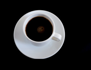 Coffee in a white mug on top on a black background. Suitable for background