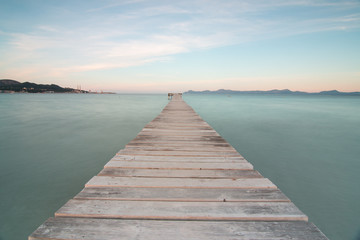 Image of a wooden pier to the sea, with silky water on the island of Mallorca. Long exposure technique