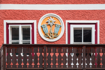 View of the facade of a traditional house featuring the pictorial relief of Alpine flowers gentian...