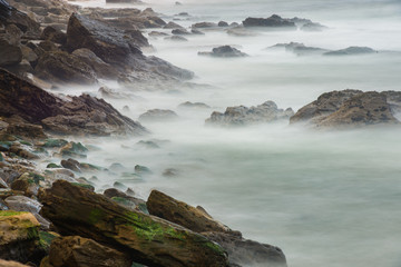 Long exposure photography of sea waves breaking against the rocks of the breakwater in Porto Novo