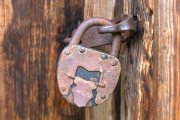 Old iron lock on a wooden brown rustic door.Close up.Selective focus.Concept of decoration,vintage design.