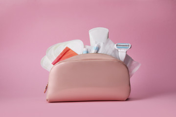 Fototapeta na wymiar Hygiene feminine pads, tampon and female razor in the cosmetic bag on pink background. Menstrual cycle. Caring for women's health.