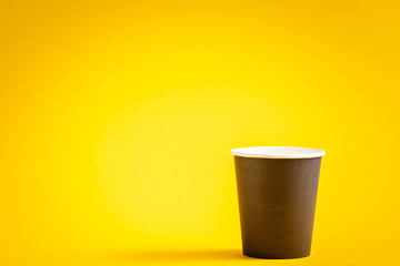 Paper coffee container on yellow background