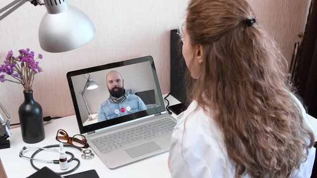 Telemedicine. Consultation with physician through webcam video call. Doctor talking to comlaining patient using video chat application on laptop