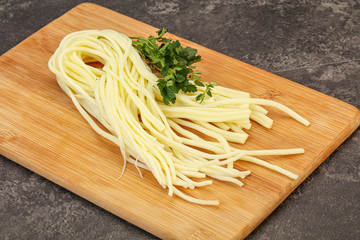 Chechil spaghetti cheese over board