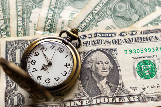 Vintage pocket watch on US dollar banknotes. Financial concept of time and money