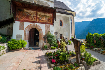 The cemetery surrounding the Parish Church of Hallstatt, Salzkammergut region, OÖ, Austria, and a beautiful fresco above the entrance of the church