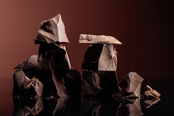 Pieces of dark chocolate on a dark background.