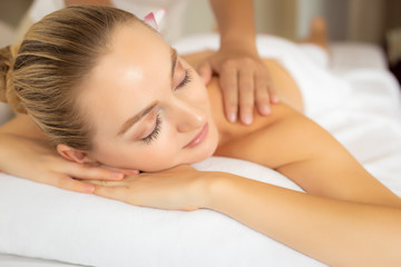 Obraz na płótnie Canvas Beautiful woman get massage on back on spa bed at spa salon. Massage therapist massage, treatment back. Customer girl get relaxed, tranquility. Oriental massage in luxury spa room. spa concept