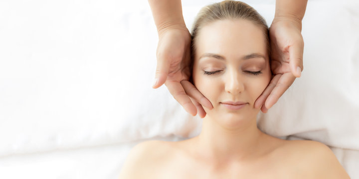 Beauty Woman Having Massage And Scrub On Spa Bed At Spa Salon. Oriental Massage Therapist Massage And Scrub Customer Face, Rejuvenating Look Younger Facial Skin. Spa Treatment. Top View, Copy Space