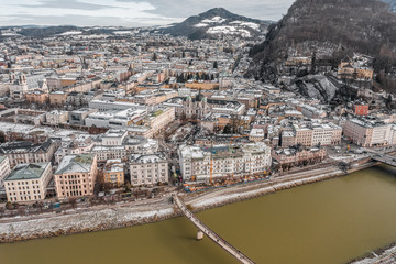 Aerial drone shot view of snowy north bank of Salzburg with view of Holy Trinity Church