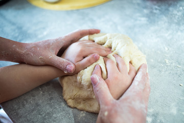 Mom and baby make dough from flour
