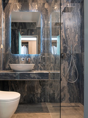 Front view of contemporary gray marble bathroom with vessel bowl sink, mirror back light, glass...