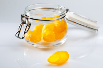 yellow silk cocoon of a silkworm for face cleaning in a glass jar on a light background