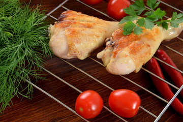 chicken legs in spices with tomatoes, herbs, parsley and hot peppers on the grill