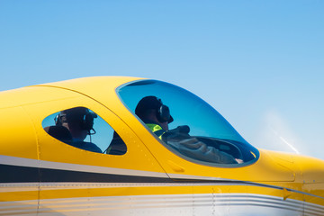 cockpit of a yellow ultra-light aircraft in the sky