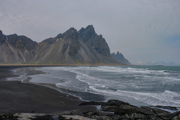 Fototapeta na wymiar The Vestrahorn mountain on the Icelandic coast jut directly out of the ocean
