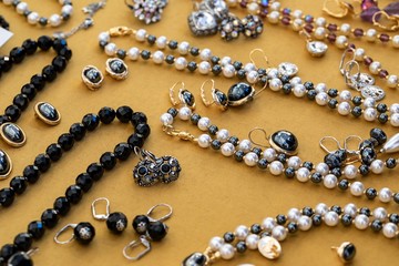 Beads and earrings made of semiprecious stones, yellow background, top view of fashion luxury women accessories, jewerly and shopping concept 