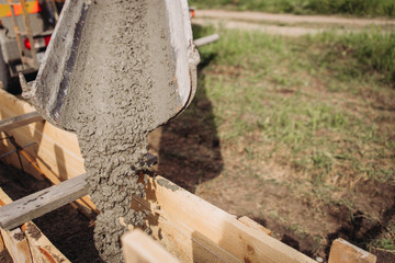 Filling concrete in a wooden box, building the foundation of an apartment building, shovel in concrete
