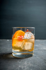 Old fashioned beverage with orange slices on rustic background. Selective focus. Shallow depth of field.