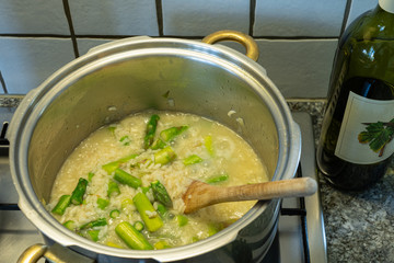 Cooking some Risotto rice with asparagus, onion and white wine.