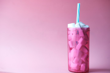 sugar cube in a plastic container on pink background 