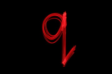 Long exposure photograph of the letter q in neon red colour fairy lights against a black...