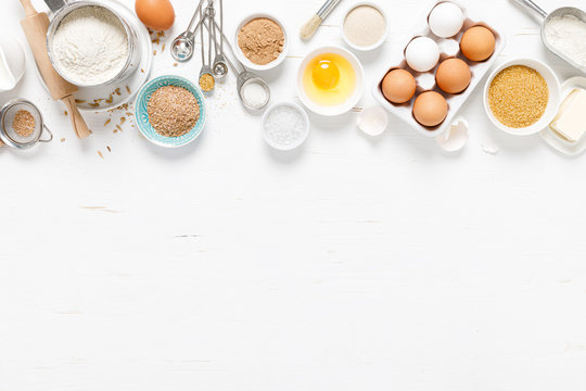 Baking homemade bread on white kitchen worktop with ingredients for cooking, culinary background, copy space, overhead view