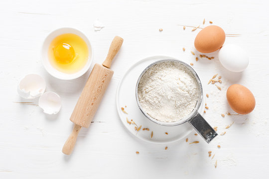 Flour and eggs on white kitchen worktop, baking culinary background, copy space, overhead view