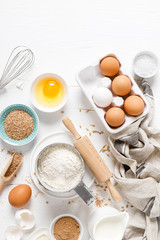 Baking homemade bread on white kitchen worktop with ingredients for cooking, culinary background, copy space, overhead view