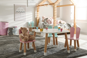 Small table and chairs with bunny ears in children's bedroom interior