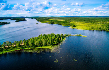 Aerial top view of blue lakes with islands and green forests in Finland.