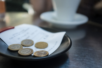 Check and euro coins on a table in a restaurant in Europe.