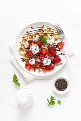 Belgian waffles with fresh strawberry, chocolate topping and whipped cream