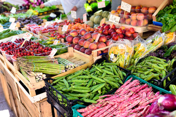 Traditional food market in the center of Bologna, Italy. Fresh vegetables and fruits on market stall. Selective focus.