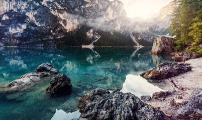 Famouse lake Braies during sunrise. Wonderful sunny landscape in dolomites Alps. Amazing nature Scenery. Lake Braies is also known as Lago di Braies