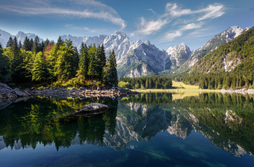 Scenic image of fairy-tale Mountain lake under sunlit. Amazing Nature Landscape. Wonderful sunny morning. Beautiful scenery of the majestic Fusine lakeside in Julian Alps. Perfect natural background