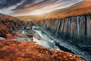 Scenic image of Iceland nature landscape. Studlagil basalt canyon during sunset, Iceland.