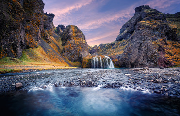 Fototapeta na wymiar Amazing nature landscape with colorful sky during sunset. Stjornarfoss Waterfall in South Iceland. Iconic location for landscape photographers and bloggers. Best famouse travel locations. Wallpaper