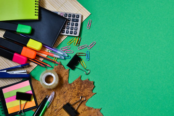 Stationery for school on a green background. Diary, pens, pencils, calculator, notepad. Back to school. The concept of study, school. Place for text.