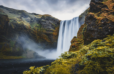 Icelandic Landscape. Classic long exposure view of famous Skogafoss waterfall with colorful sky during sunset. Skoga river, highlands of Iceland, Europe. Popular Travel destinations. Amazing nature.