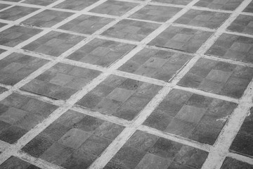Squares on the floor monochrome. Granite surface black and white. Square marble tiles on the ground. Gray mosaic pavement. Ceramic texture. 