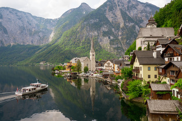 Fototapeta premium Scenic view of the famous mountain village Hallstatt in the Salzkammergut region, OÖ, Austria, with the ferry approaching the pier