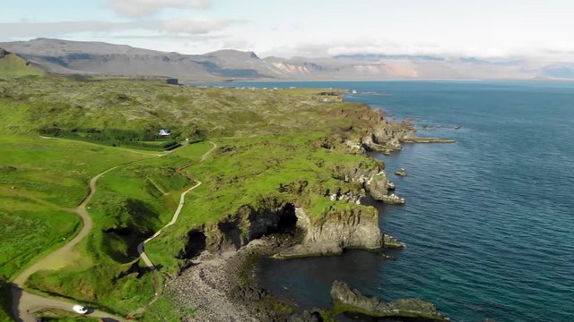 Arnarstapi coastline in sumemr season, Snaefellsnes peninsula, Iceland. Aerial view from drone. Slow motion