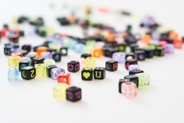 Colorful alphabets beads on white background, different colors with letters, concept image