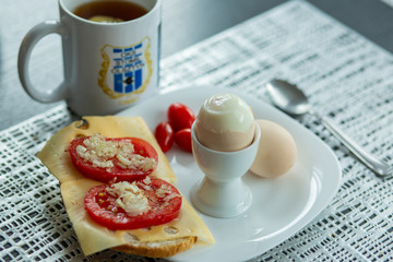 Zdrowe śniadanie jako na miękko i kanapka z serem i pomidorami oraz herbata  - obrazy, fototapety, plakaty
