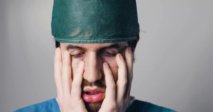 Medico disperato si mette le mani in faccia