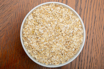 Oatmeal in a white Cup on a brown table.