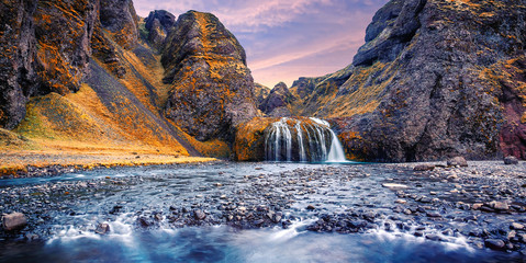 Fototapeta na wymiar Stjornarfoss Waterfall in South Iceland. Incredible nature landscape with colorful sky during sunset. Iconic location for landscape photographers and bloggers. Best famouse travel locations. Wallpaper