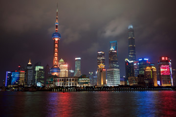 Night skyline of colorfully lighted Oriental Pearl TV Tower and other skyscrapers across Huangpu river, as seen from the Bund.